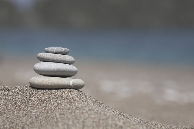 A diverse stack of books and a tablet on a wooden table, symbolising accessible information in multiple formats.